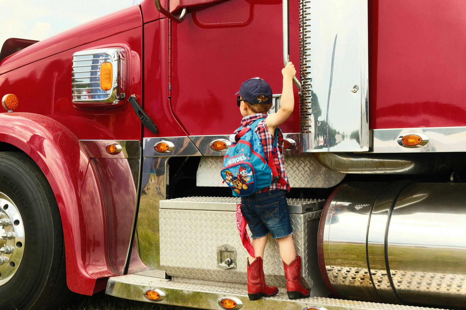 Truck driver family, child climbing into a semi truck cab