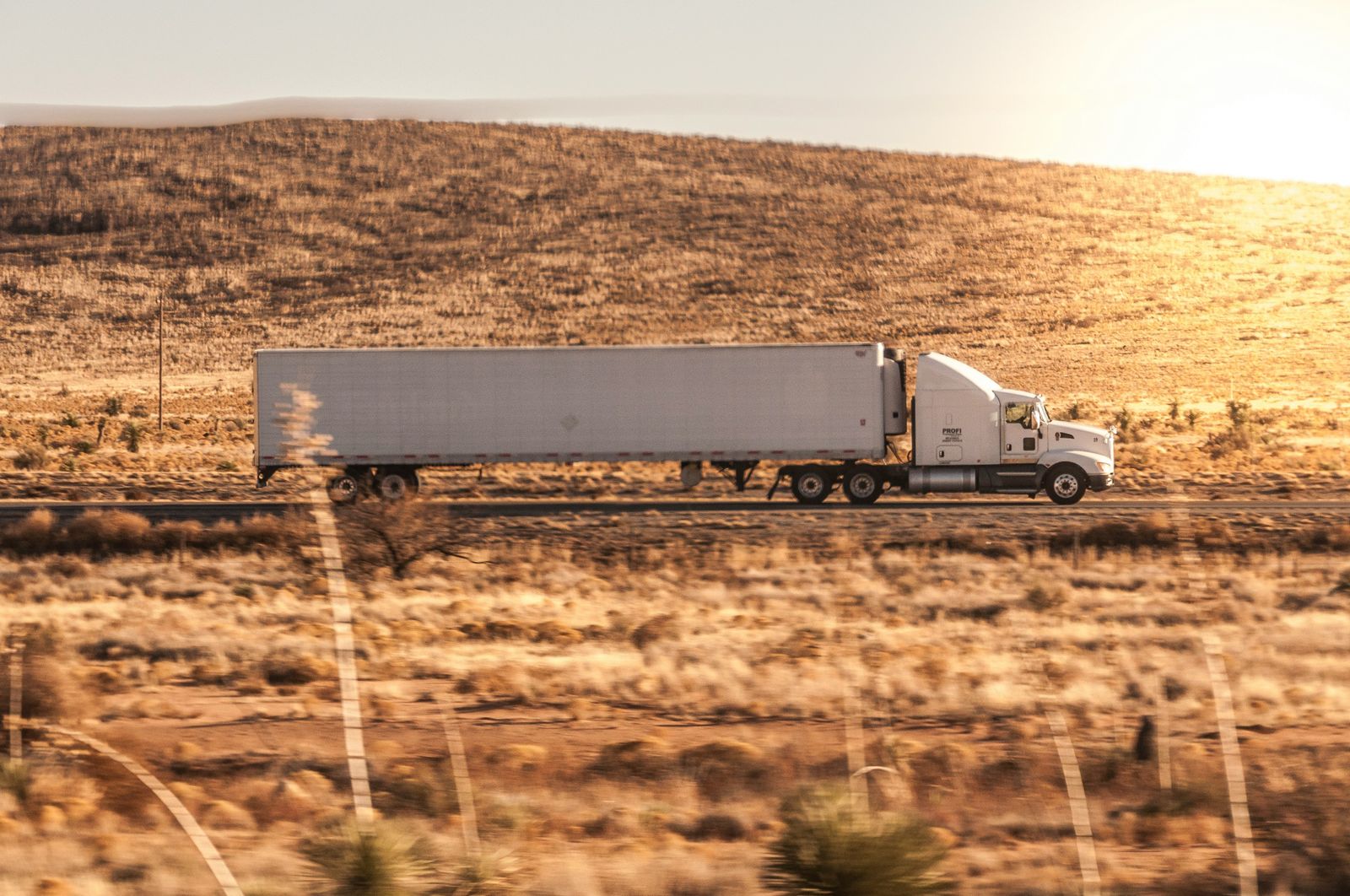 Trucker driving semi-truck on highway - health insurance for truck drivers