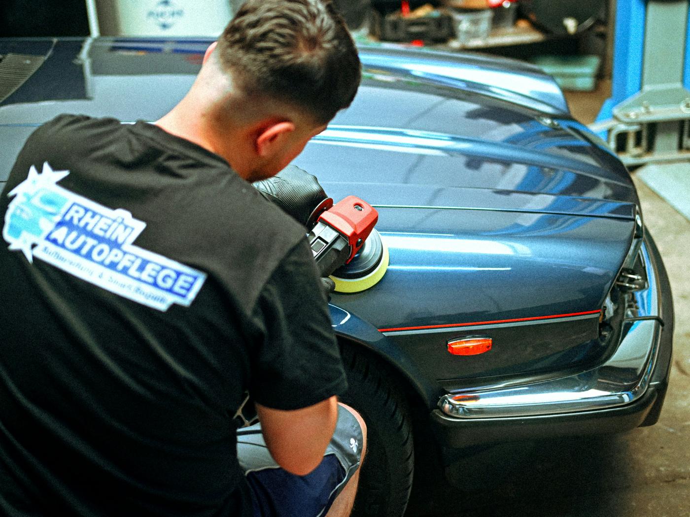 Auto repair shop technician at work, covered by group health insurance