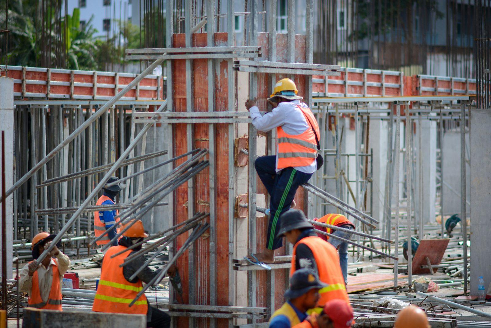 Construction crew working on a rebar column, representing health insurance for construction workers