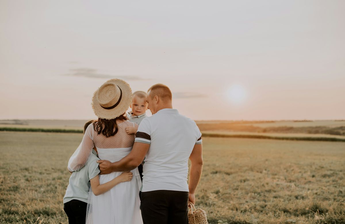 Familia abrazada en un campo al atardecer durante la inscripcion abierta 2027