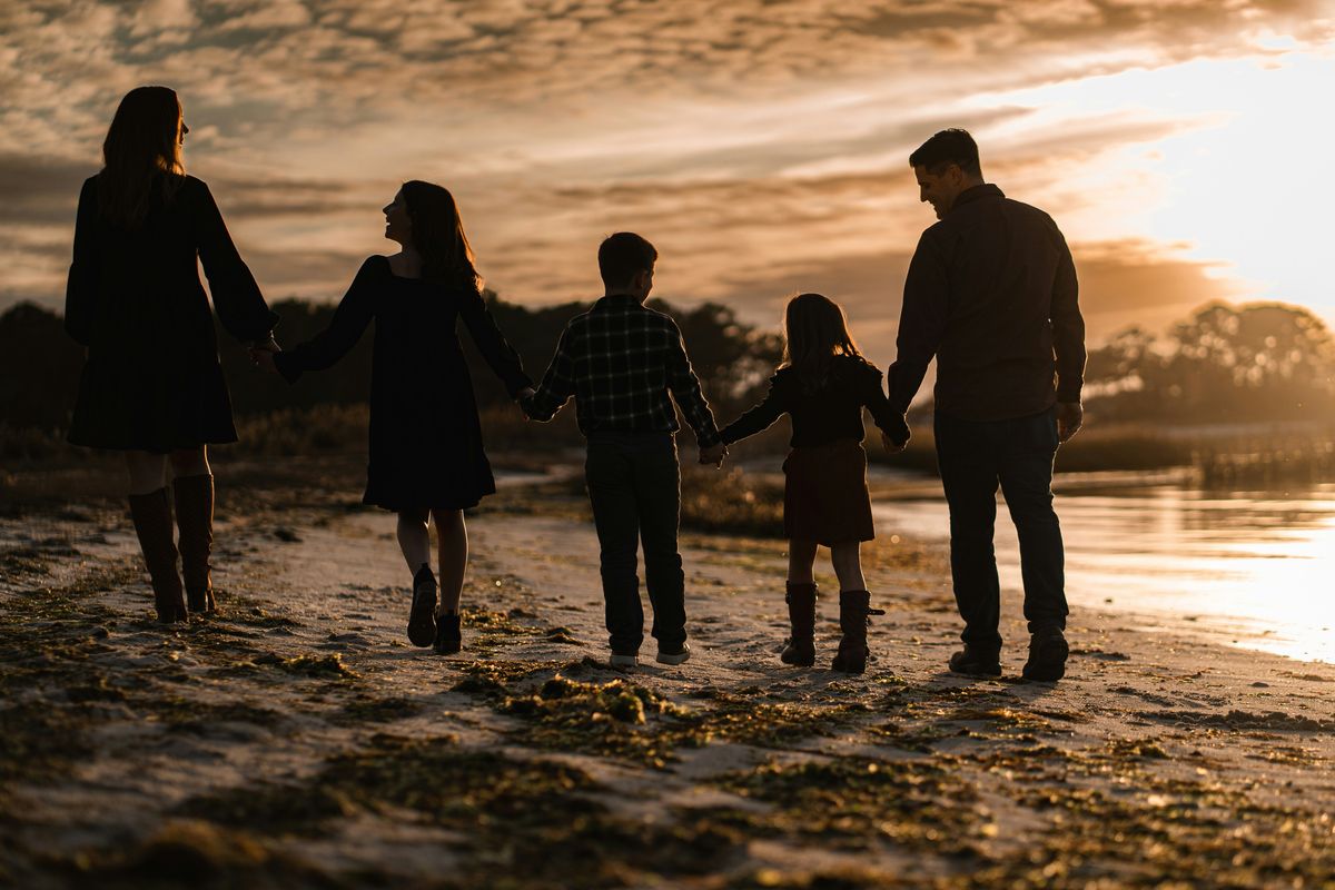 Truck driver's family walking hand in hand on the beach at sunset back home