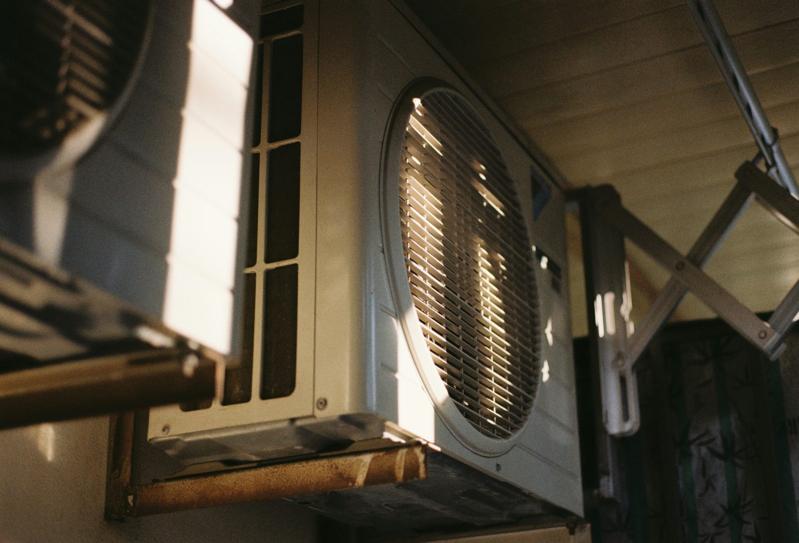 Outdoor HVAC condenser unit in afternoon light, representing health insurance for HVAC companies