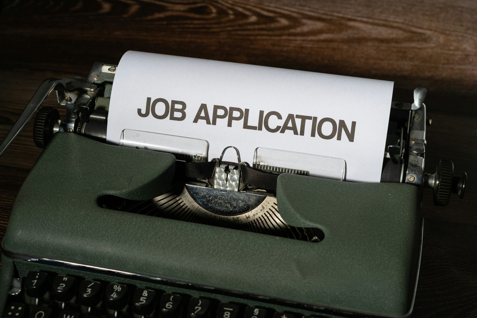 Job application in a typewriter, representing how employee health insurance improves recruitment and retention
