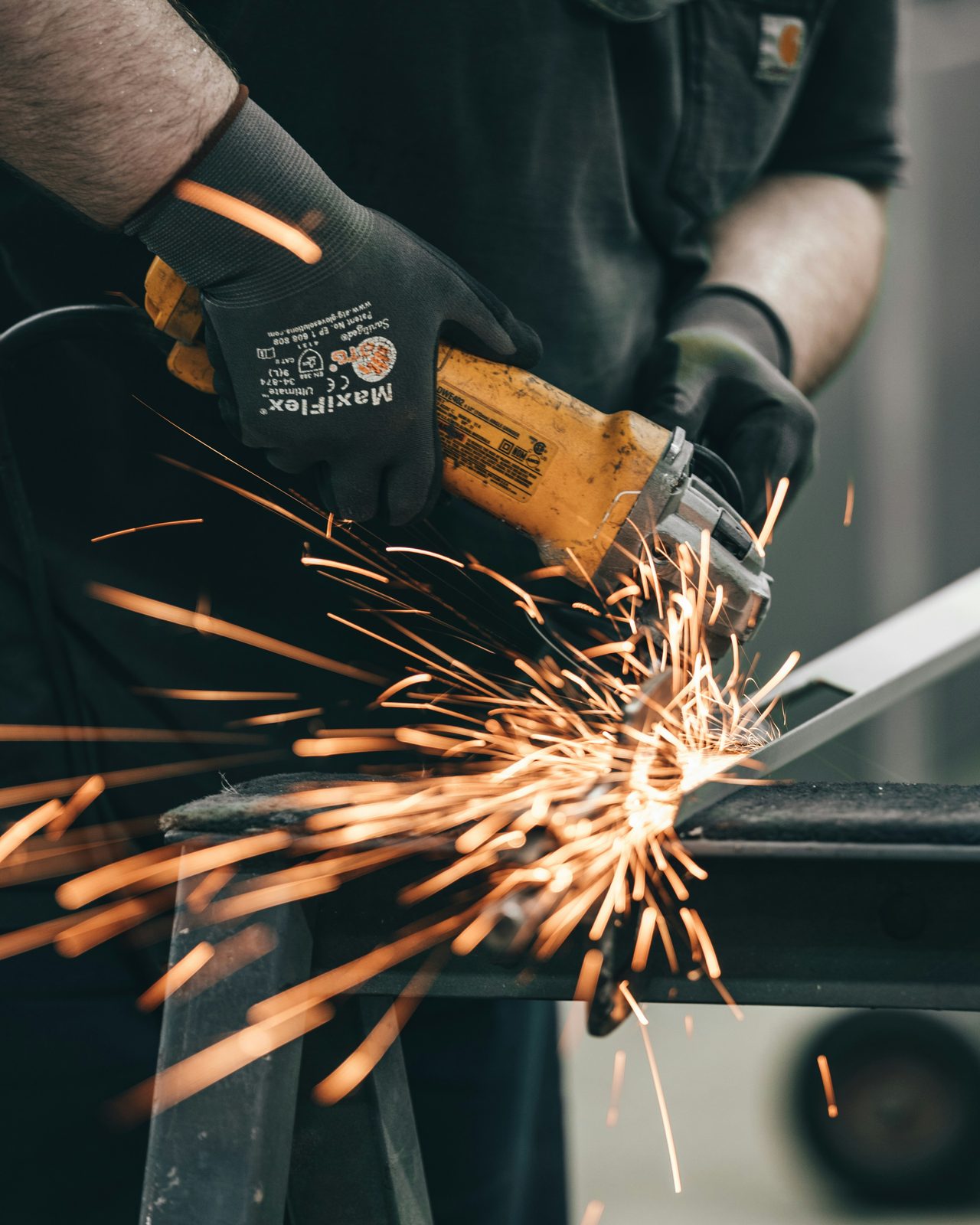 Metal fabricator using an angle grinder, representing skilled trade contractors covered by group health insurance