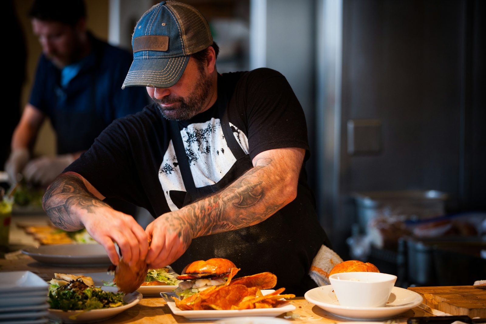 Chef plating dishes on a restaurant pass, representing group health insurance for restaurants